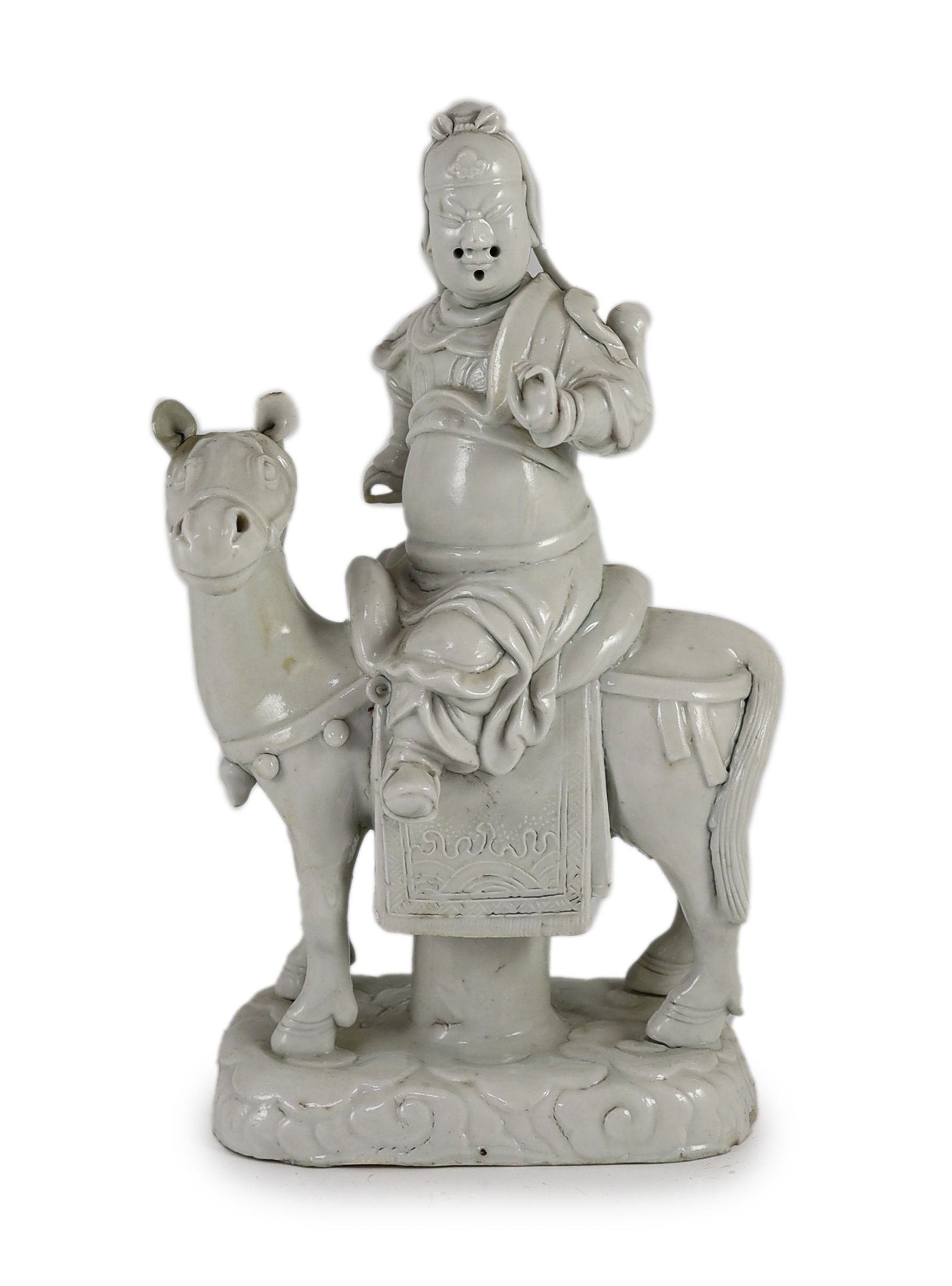 A Chinese blanc-de-chine equestrian group of Guandi seated astride a horse, Dehua kilns, Kangxi period, 30cm high, minor faults